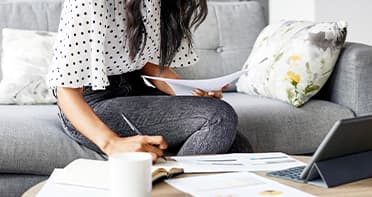 Close up of woman with document on sofa.