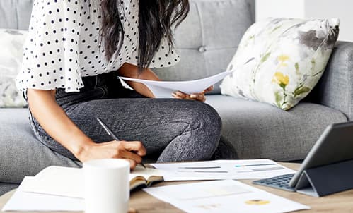 Woman on sofa with document.