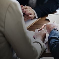 3 people meeting whilst one takes notes.