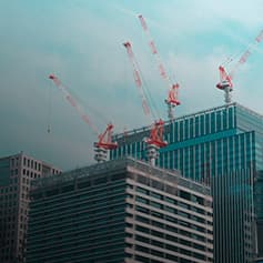 Cranes sitting on buildings.