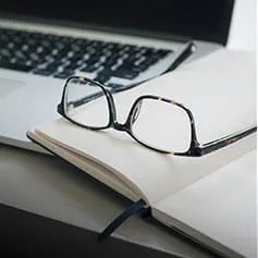 Glasses sitting on notebook.