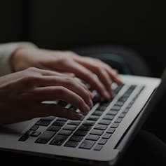 Person typing on laptop.