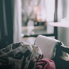 Dishevelled blankets on bed.