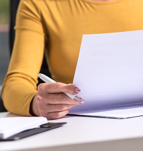 Woman in yellow top looking at a document.