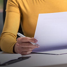 Woman in yellow top looking at a document.