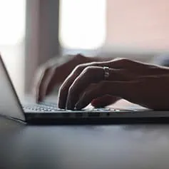 Person typing on laptop.