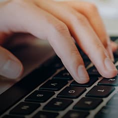 Fingers typing on a keyboard.