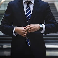 Man buttoning up suit jacket.
