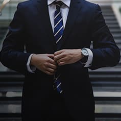 Man buttoning up suit jacket.