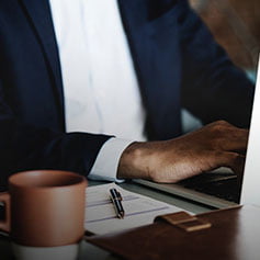 Businessman typing on laptop.
