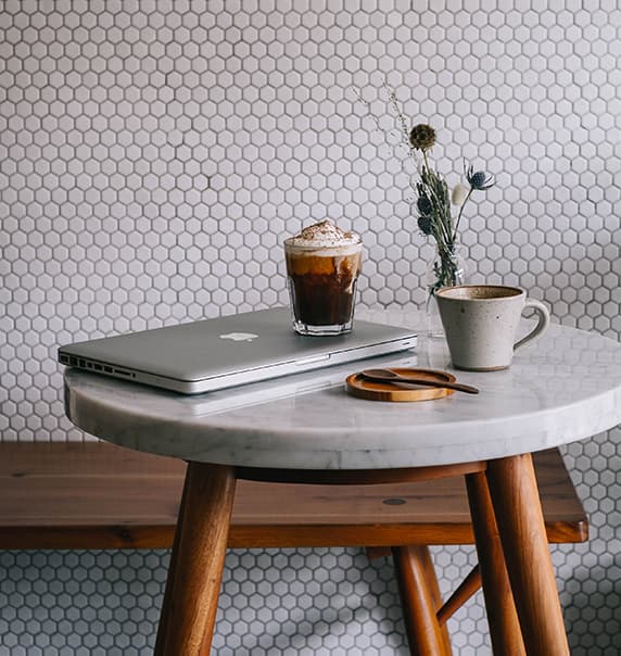 Laptop and coffee on marble coffee table