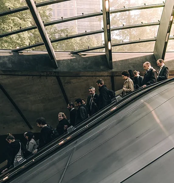 Convoy of people descending on escalator