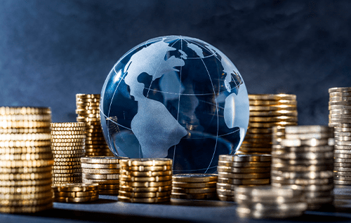 A glass globe surrounded by coins.