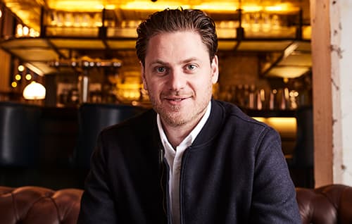 Jeremy Simmonds headshot in restaurant/bar.