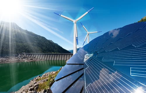 Solar panels and wind turbines next to mountain lake