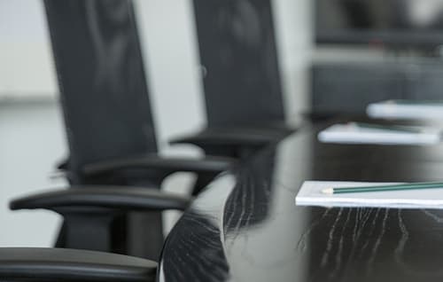 Boardroom desk and chairs with pads and pencils