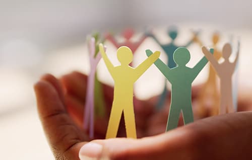 Coloured people paper chain in palm of hand